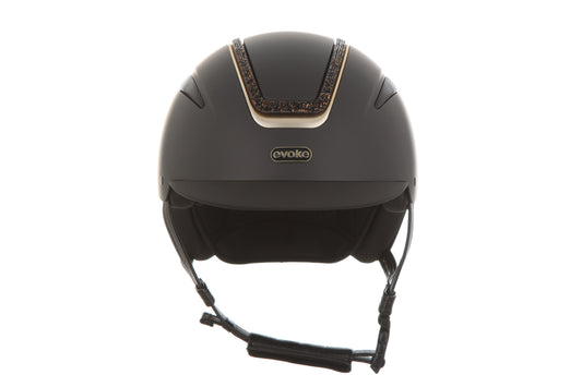 A matte black riding helmet with a decorative gold and brown patterned trim on the top center, featuring the 'Evoke' brand logo on the front, set against a plain white background.